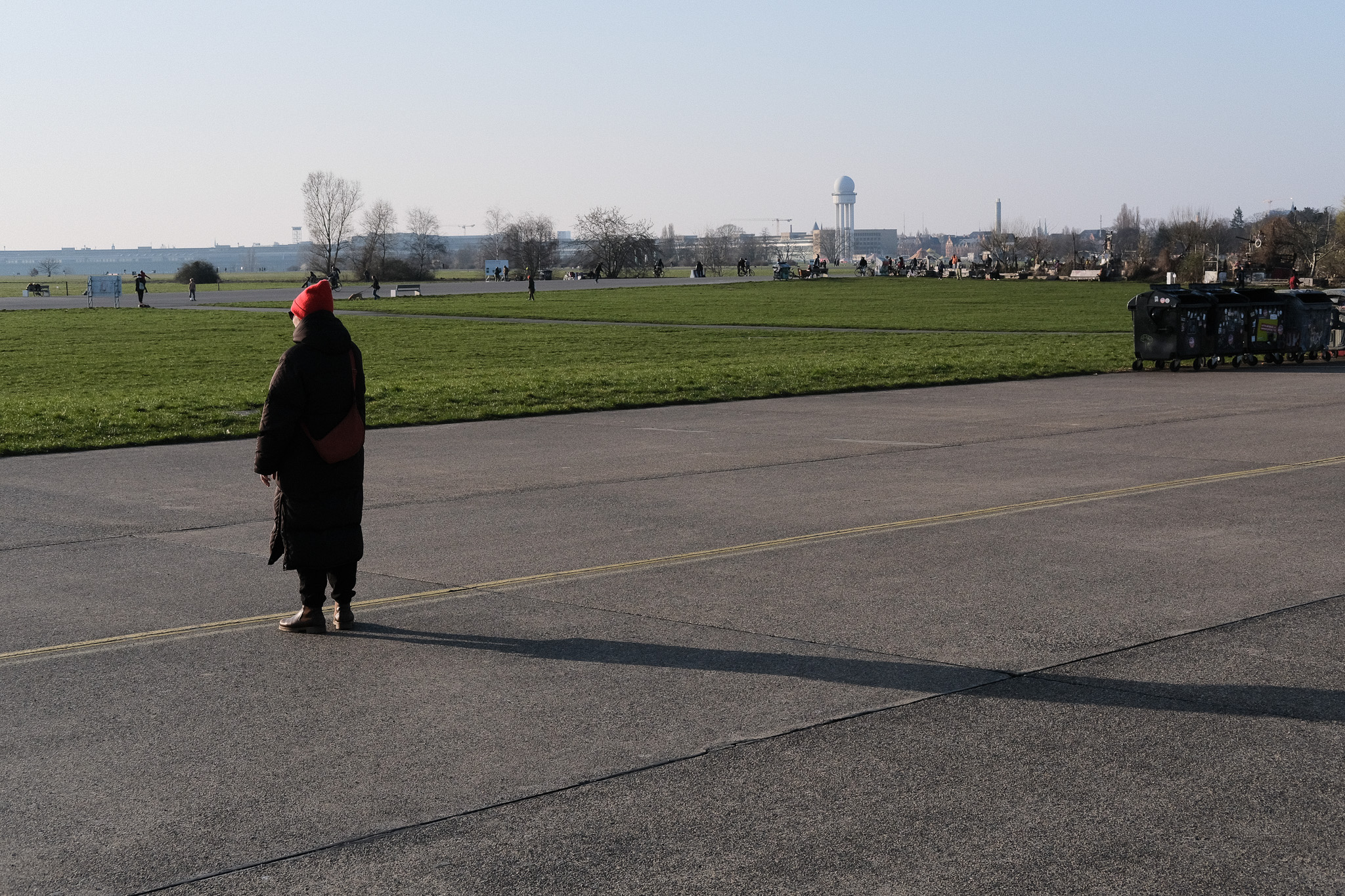 Person in a red hat walking on the former runway at Tempelhofer Feld